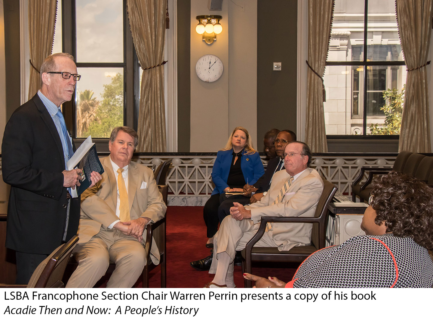 LSBA Francophone Section Chair Warren Perrin presents a copy of his book Acadie Then and Now: A People's History