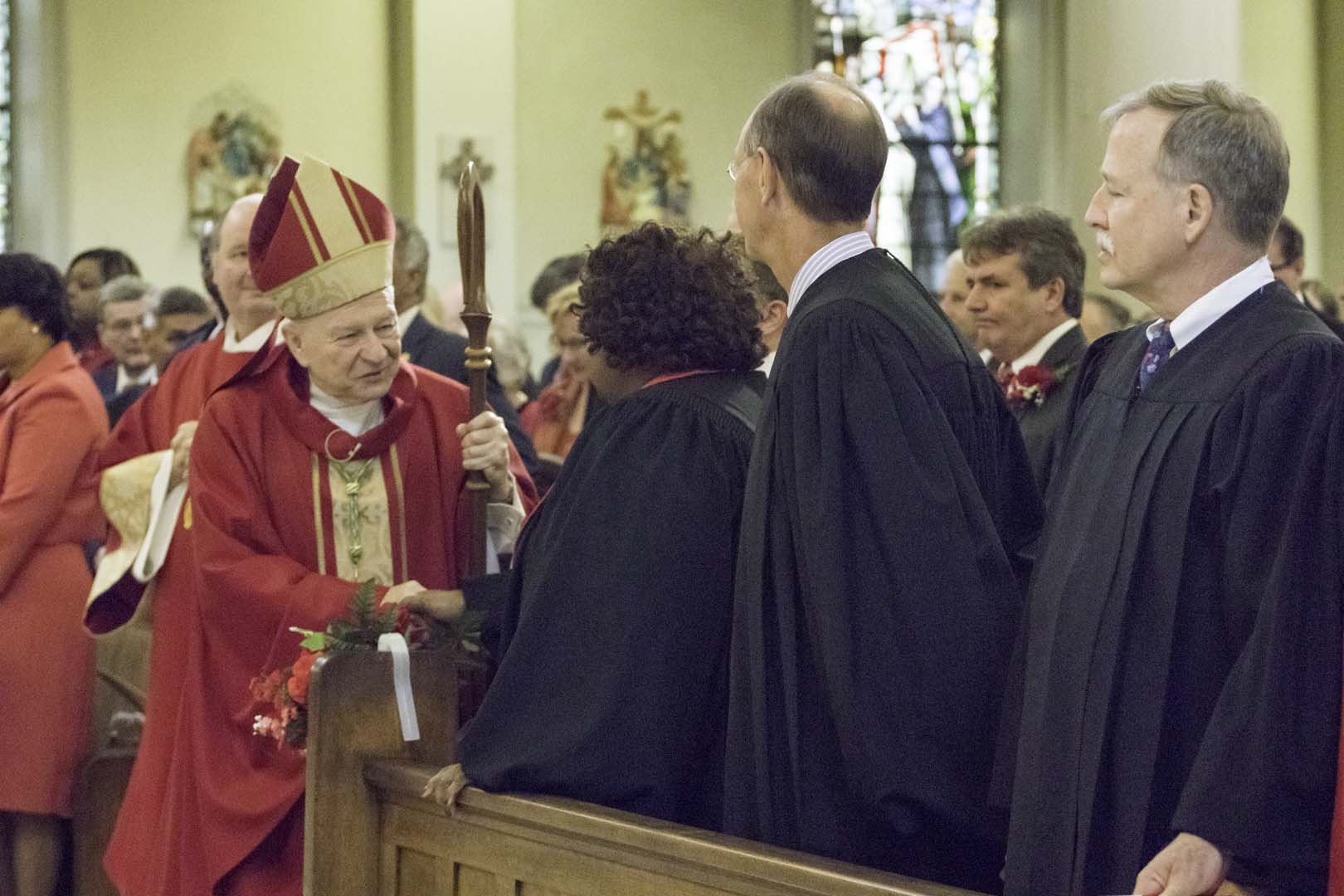 The Most Reverend Gregory M. Aymond, Archbishop of New Orleans pauses to greet Honorable Chief Justice Bernette Joshua Johnson, Associate Justice John L. Weimer and Associate Justice Scott J. Crichton.